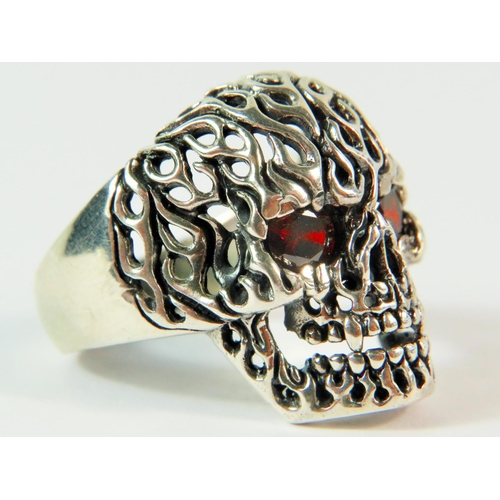 117 - 925 Gents Silver Skull Ring with Pierced flaming skull mount and Garnet Eyes. Finger size 'V'   11.9... 