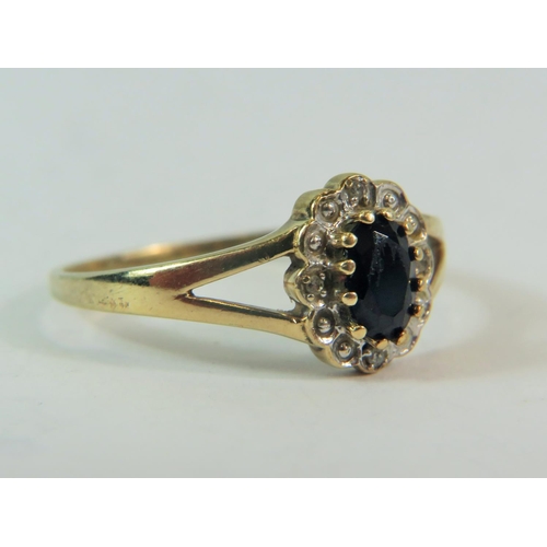 180 - 9ct Yellow Gold Ring set with a large central Sapphire with Four Diamond surround.  Finger size @T' ... 