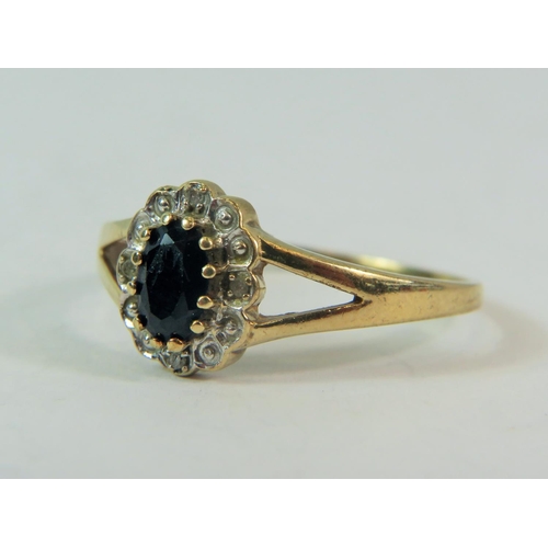 180 - 9ct Yellow Gold Ring set with a large central Sapphire with Four Diamond surround.  Finger size @T' ... 