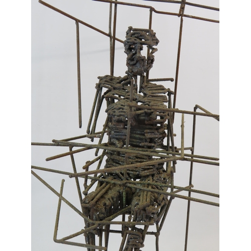 380 - Wire sculpture of a person sittting in a chair, it measures 22.5