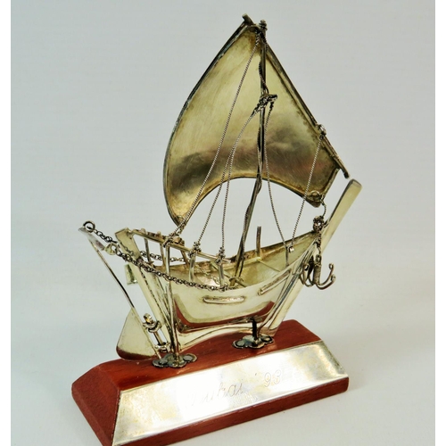 245 - 925 Silver model of an Arab Dhow on a wooden and silver stand.  Measures 6 inches tall. See photos.