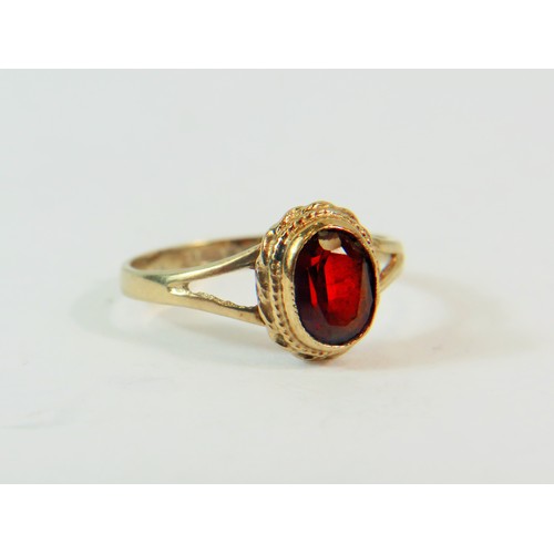 207 - 9ct Yellow Gold set with an Oval 5mm Garnet.  Finger size 'K-5'   1.6g    191-29-9