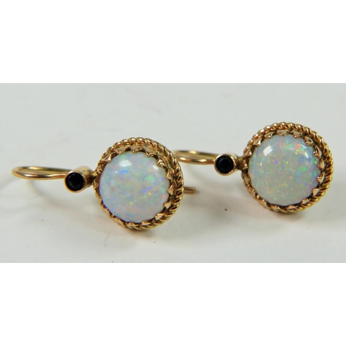 317 - Pair of Opal and Sapphire earrings set in mounts which are marked 14ct. Opals measure 10mm in diamet... 