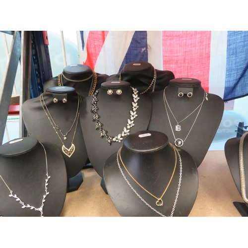 255 - 8 Black jewellery stands and a selection of costume jewellery earrings and necklaces.