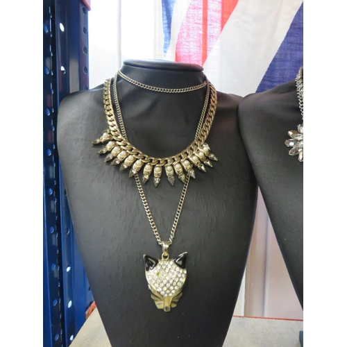 255 - 8 Black jewellery stands and a selection of costume jewellery earrings and necklaces.