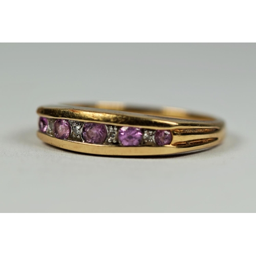 448 - 9ct Yellow Gold ring set with Pink and clear Diamonds in an oval trench setting.   Finger size Q    ... 