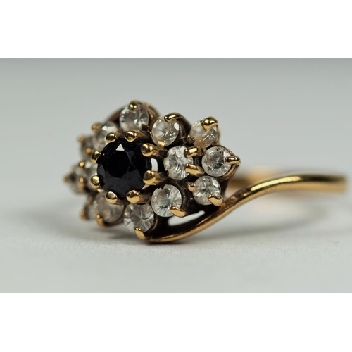 474 - 9ct Yellow Gold ring set with a central Sapphire with CZ cluster surround.    Finger size       2.7g