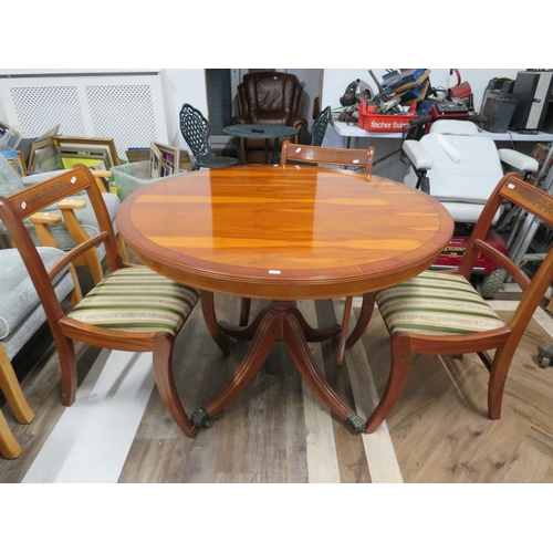 919 - Round, Tilt top table in Yew wood veneer supported by four bracket legs on castors along with four m... 