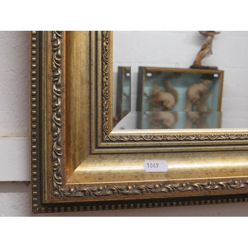 1049 - Bevelled glass mirror in a beautiful gilt frame. 25 x 21 Inches. See photos. (Barn). S2