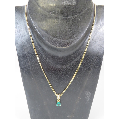 311A - Pretty Emerald and Three Diamond set pendant in 9ct Yellow Gold, hung on an 18 inch flat link 9ct Ye... 