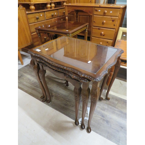 659 - Nest of three darkwood tables each with glass protective tops. Largest being H:22 x W:23 x D:17 Inch... 