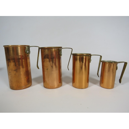 658 - 4 Graduated Copper and brass measuring cups.