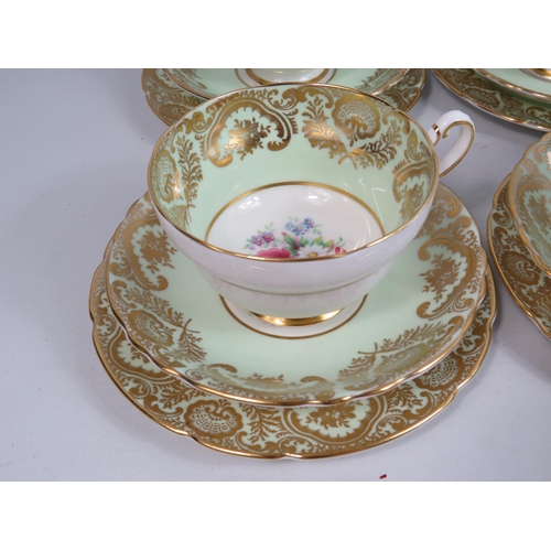 253 - 6 Paragon china trios, green and gilt with floral decoration.