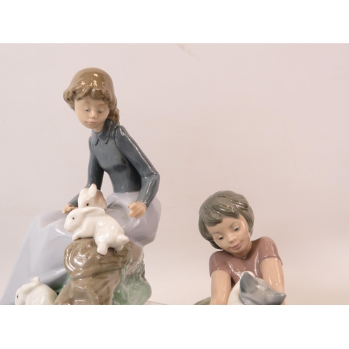 18 - 2 Nao Lladro figurines, a girl with 3 rabbits and a girl with a kitten.  The tallest measure 6 3/4