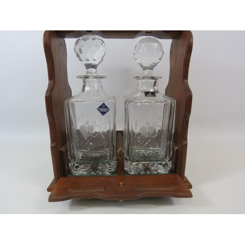 70 - Vintage Tantalus with brass detail and a pair of national blood service decanters.