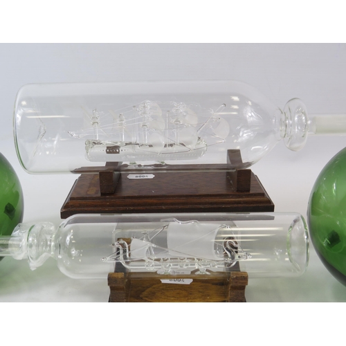 144 - 2 Glass ships in bottles and 2 green glass shipping bouys.