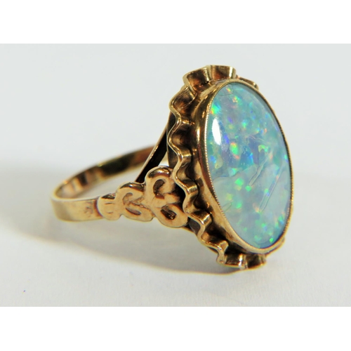 311 - Yellow metal ring (testing 9ct) set with large reconstitued Opal which measures 20 x 14 mm  Finger s... 