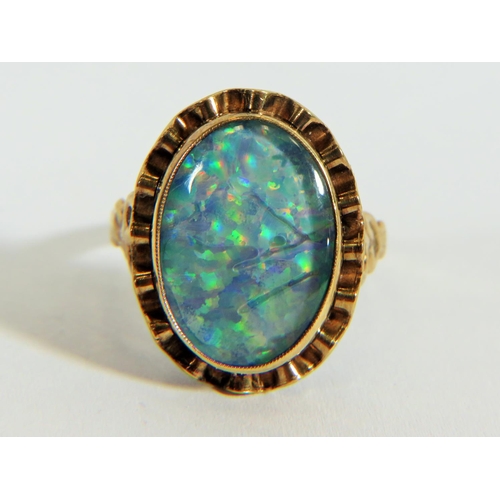 311 - Yellow metal ring (testing 9ct) set with large reconstitued Opal which measures 20 x 14 mm  Finger s... 