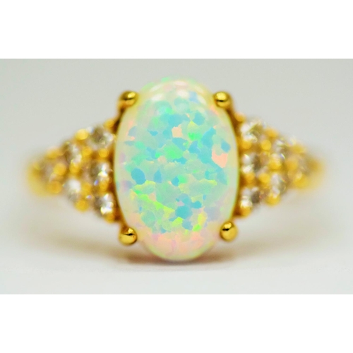 314 - 14ct Yellow Gold Ring set with a large central Opal which measures 12 x 8mm with 12 clear gemstones ... 