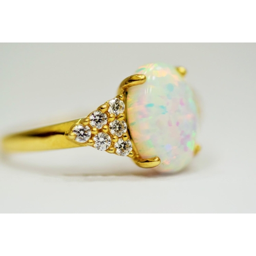 314 - 14ct Yellow Gold Ring set with a large central Opal which measures 12 x 8mm with 12 clear gemstones ... 