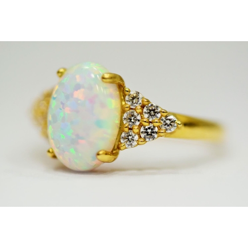 314 - 14ct Yellow Gold Ring set with a large central Opal which measures 12 x 8mm with 12 clear gemstones ... 