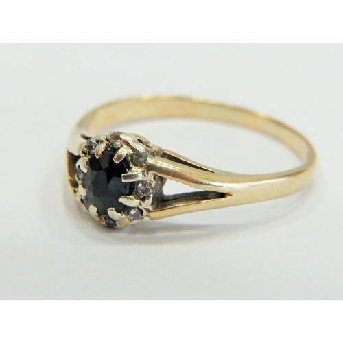 356 - 9ct Yellow Gold ring set with a central Sapphire with large claw mounts and surrounded by small Mele... 