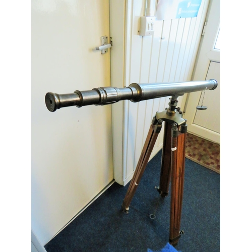 3 - Large metal telescope on a wooden and brass adjustable Tripod mount.

Twist grip zoom, end lens cove... 