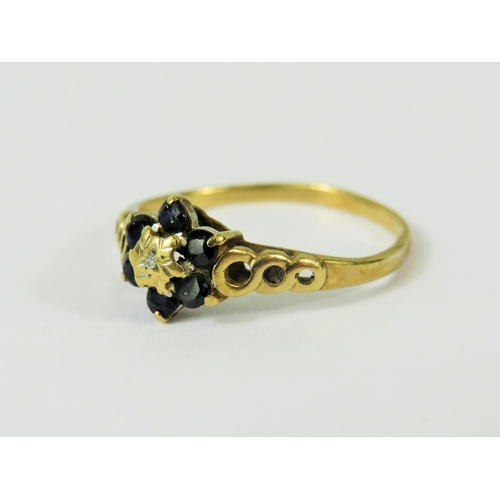 115 - 9ct Yellow Gold ring set with a small central Diamond and surrounded by  six small Sapphires.   Ring... 