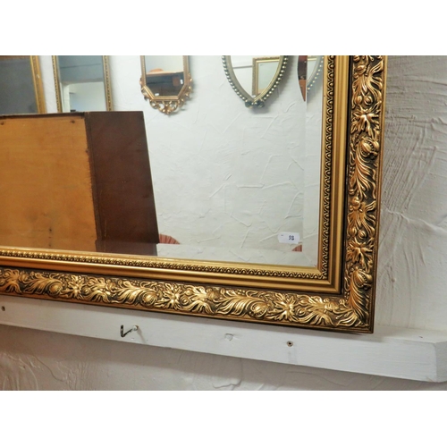 98 - Bevelled glass mirror with gilt effect composite frame which measures approx 39 x 28 inches. See pho... 