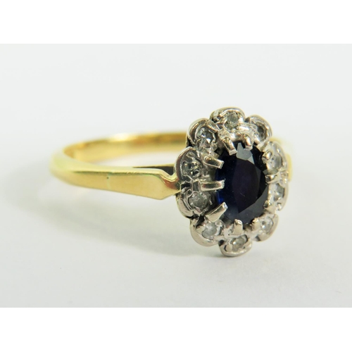 134 - 18ct Yellow Gold Ring set with a Central Sapphire and Diamond surround.  Finger size 'O'  3.3g