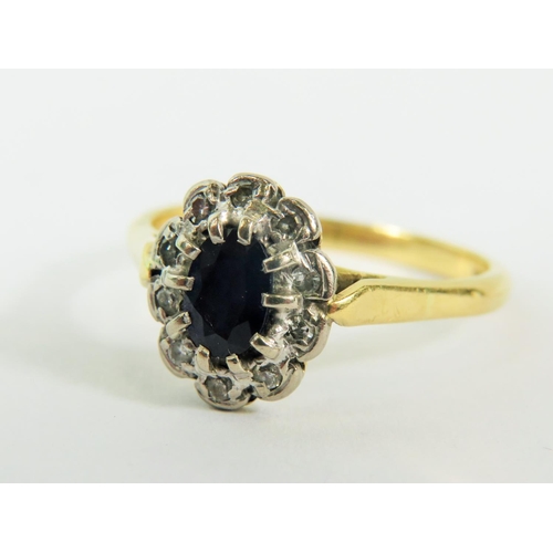 134 - 18ct Yellow Gold Ring set with a Central Sapphire and Diamond surround.  Finger size 'O'  3.3g