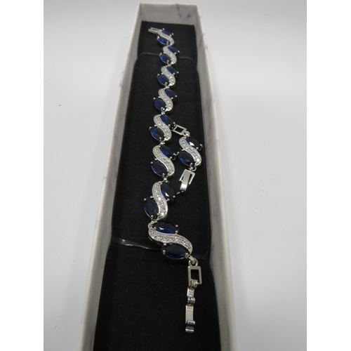 255 - 925 Silver bracelet set with blue and clear gemstones and has a extention piece.