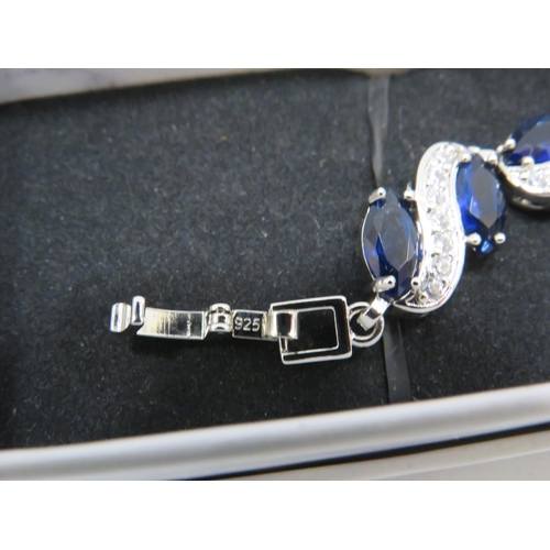 255 - 925 Silver bracelet set with blue and clear gemstones and has a extention piece.