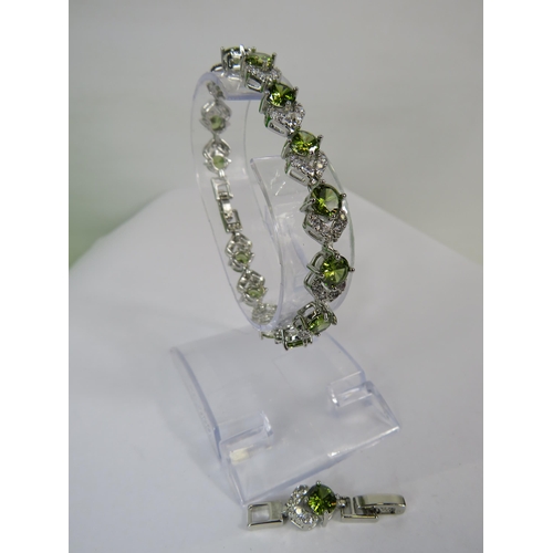 257 - 925 silver bracelet set with pale green and clear gemstones.