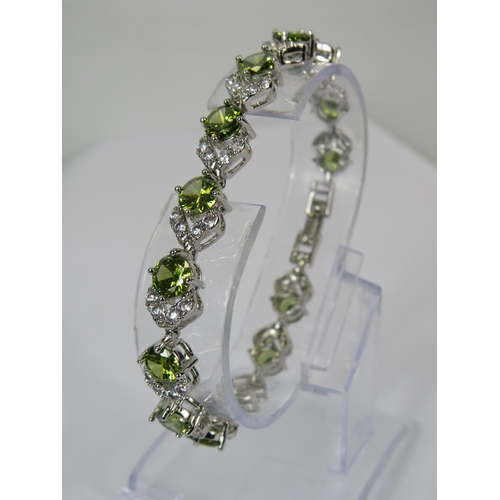 257 - 925 silver bracelet set with pale green and clear gemstones.