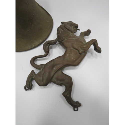 314 - Cast brass rearing lion wall plaque and a vintage brass bell.