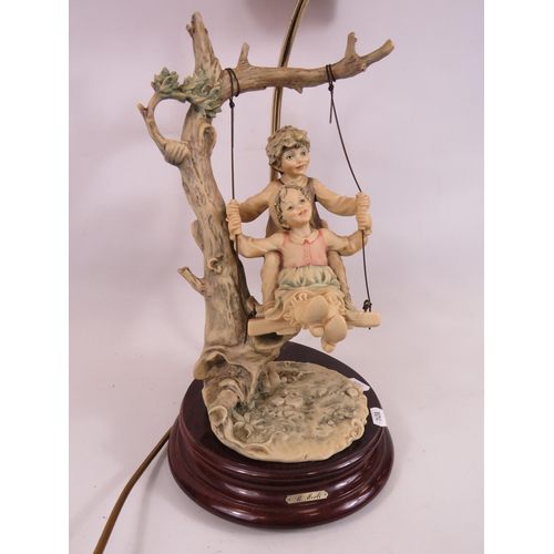 500 - B Merli Italian figural lamp of children on a swing, 21 