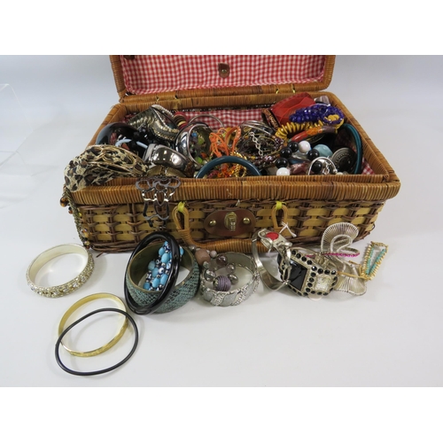 172 - Wicker basket containing a large quantity of costume jewellery bracelets.