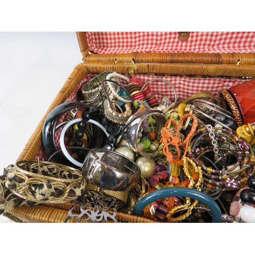 172 - Wicker basket containing a large quantity of costume jewellery bracelets.