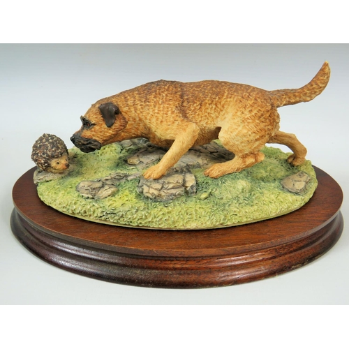 81 - Border Fine arts model of a Border Terrier with a Hedgehog. Mounted on wooden base it measures appro... 