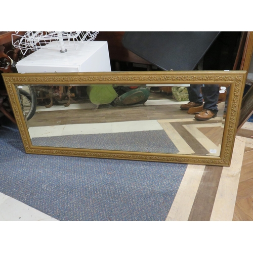 1143 - Large Bevelled Glass mirror with wall fixing lugs and attractive carved gilt frame. Measures 24 x 56... 