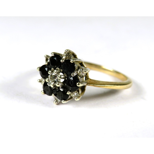 300 - 9ct Yellow Gold Ring set with a small central Diamond with Sapphires and Diamonds in a flower patter... 