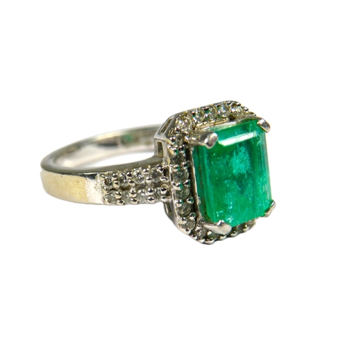 442 - 900 Platinum Ring set with a large Central Emerald of approx 2.16 cts and surrounded by Multiple Dia... 