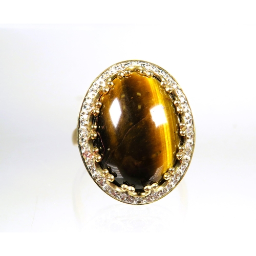 448 - 9ct Yellow Gold ring set with a large 'Tiger's Eye' stone which measures approx 20 x 14 mm with smal... 