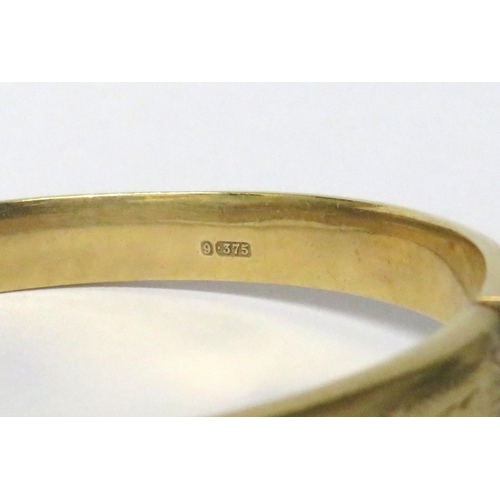 203A - 9Ct Yellow Gold etched Bangle with safety chain fitted. Weight 11.8g