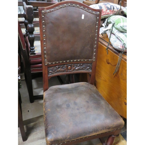 184 - Brown leather carved oak chair with brass buttons. 40