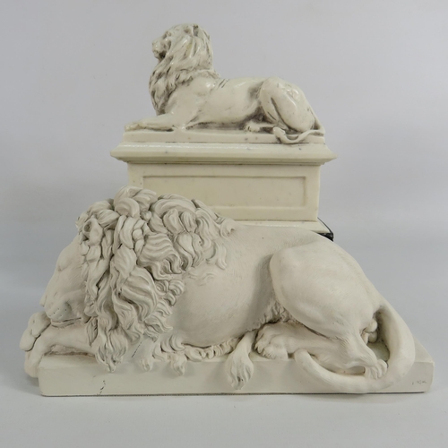 46 - Sculpture of the chatsworth sleeping lion plus one other recumbent lion on a plinth.