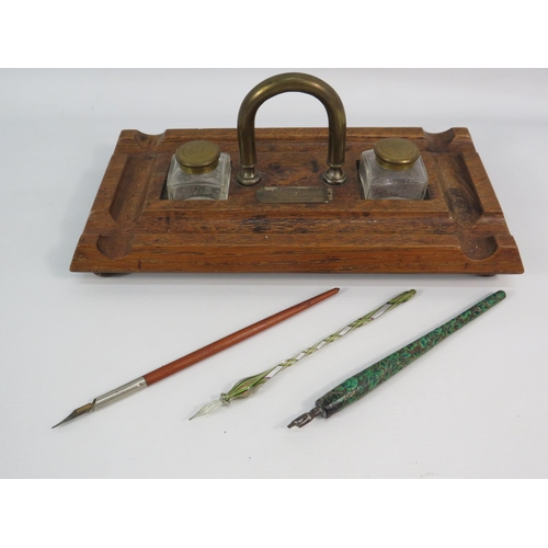 185 - Antique wooden and brass desk tidy with glass ink wells and three antique dip pens. Plaque dated 190... 