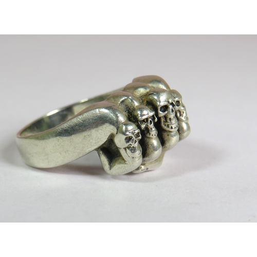 319 - 925 Sterling Silver ring set as a fist with four Skull rings on the Fingers.  Finger size V-5  9.1g