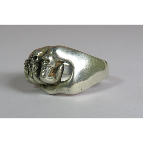 319 - 925 Sterling Silver ring set as a fist with four Skull rings on the Fingers.  Finger size V-5  9.1g